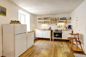 a kitchen with white cabinets and a refrigerator at Nengshof Ferienhaus Ehrenpreis in Wißmannsdorf