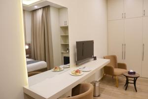 a room with a desk with a television on it at RT Serene Hotel - Larkana in Lāhori