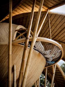 a wooden chair sitting under a roof at Cocoon Reserve in Kuta Lombok