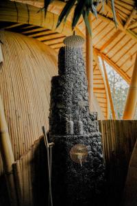 a black stone stove in a room with a roof at Cocoon Reserve in Kuta Lombok
