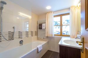 a bathroom with a tub and a sink at Pension Regina in Lech am Arlberg +33 photos