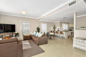 a large living room with a couch and a kitchen at The Gallipoli Residence in Long Jetty