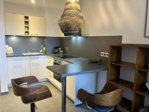 a kitchen with a black counter and two chairs at Ferienwohnung Rolofs in Bad Nenndorf