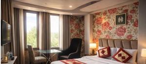 a bedroom with a bed and a table and a window at rashik stayzz in Shimla