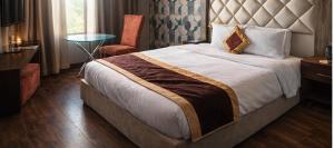 a hotel room with a large bed and a chair at rashik stayzz in Shimla