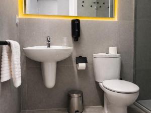 a bathroom with a white toilet and a sink at Pension Sarria in Sarria +11 photos