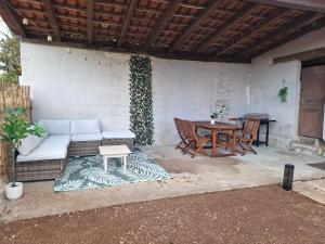 a patio with a white couch and a table at Gîte L'alcôve in Issendolus