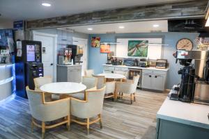 a restaurant with two tables and chairs and a kitchen at Dragonfly Inn & Suites in Hastings