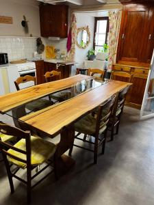 a kitchen with a wooden table and chairs at Maison de famille au plateau du Mezenc in Les Vastres