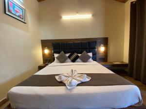 a bedroom with a large bed with a white bow on it at Hotel Panorama Lake View in Nainital +2 photos