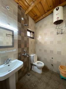 a bathroom with a white toilet and a sink at Hotel Panorama Lake View in Nainital