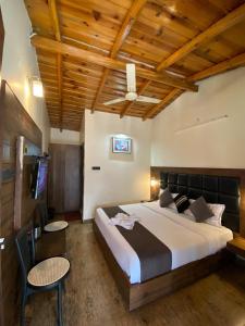 a bedroom with a large bed and a tv at Hotel Panorama Lake View in Nainital