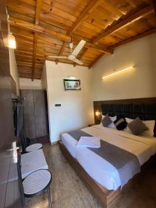 a bedroom with a large bed and two chairs at Hotel Panorama Lake View in Nainital