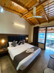 a bedroom with a large bed with a ceiling at Hotel Panorama Lake View in Nainital