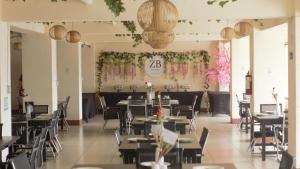 a restaurant with tables and chairs in a room at Zhongkebole Suites in Baguio