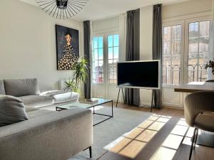 a living room with a couch and a flat screen tv at Acariciando la Catedral by apartamentoscatedralcamino in Burgos