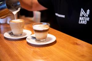 two cups of coffee sitting on a table at Alberg Naturland in Sant Julià de Lòria