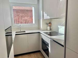 a kitchen with a window with a view of a stadium at Acariciando la Catedral by apartamentoscatedralcamino in Burgos +15 photos