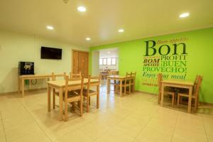 a dining room with green walls and wooden tables and chairs at Alberg Naturland in Sant Julià de Lòria +16 photos