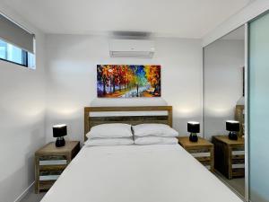a bedroom with a bed and a painting on the wall at Bay View 2-Bedroom Apartment in Batemans Bay
