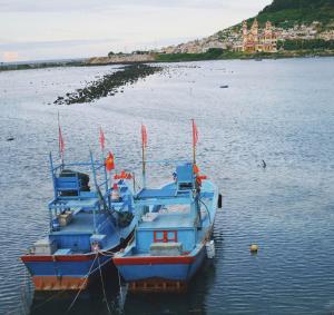 two boats are docked in a body of water at Khánh Sạn Trang Thư in Ly Son