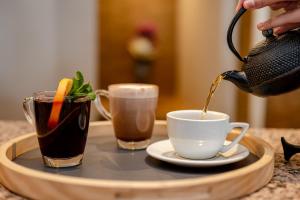 a person pouring coffee into a cup on a tray at The Bay Hotel in Cape Town