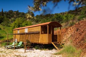 a wooden shack with a table and a chair at Finca la montaña roja in Almogía