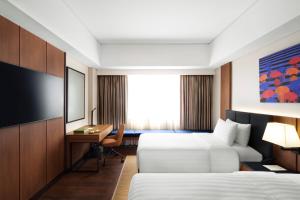 ein Hotelzimmer mit zwei Betten und einem Schreibtisch in der Unterkunft Seda Centrio Cagayan De Oro in Cagayan de Oro
