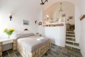 a bedroom with a bed and a staircase at Vallas Apartments & Villas in Firostefani +174 photos