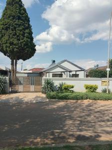 a white house with a tree in front of it at Mamela BNB in Elandsfontein