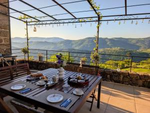 a table on a balcony with a view of mountains at Les chambres de la Bastide in Saint-Sauveur-de-Montagut +14 photos