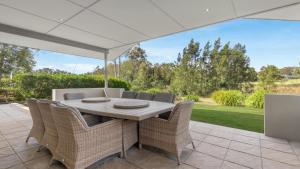a table and chairs under an umbrella on a patio at Dashaz Dream - The Vintage in Pokolbin