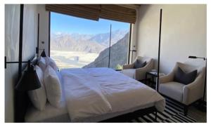a bedroom with a bed and a view of the mountains at BROQ in Skardu