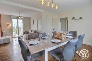 a dining table and chairs in a living room at Le palmier in Penvénan +29 photos