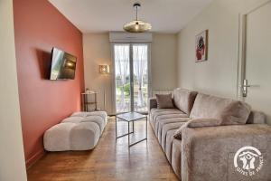 a living room with a couch and two chairs at Le palmier in Penvénan