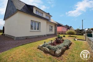 a house with a garden in front of it at Le palmier in Penvénan