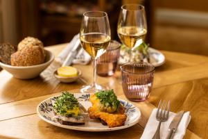 a table with a plate of food and glasses of wine at Anneberg Gæstehus in Nykøbing Sjælland