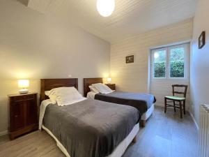 a bedroom with two beds and a window at Gite de l'isarce in Montaut