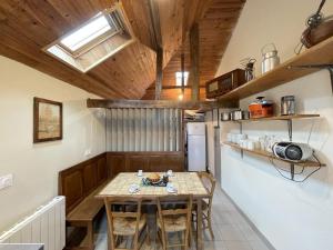 a small kitchen with a table and a refrigerator at Gite de l'isarce in Montaut