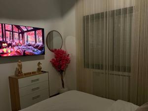 a bedroom with a bed and a tv on the wall at The Cozy Nook- luxury, privacy, with a pool and gym in Sukrah +18 photos