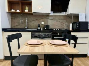 a kitchen with a wooden table with two chairs at The Cozy Nook- luxury, privacy, with a pool and gym in Sukrah