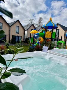 a swimming pool with a playground in a yard at Holiday Point in Międzywodzie