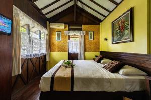 a bedroom with a large bed with yellow walls at Dedaunan Guesthouse in Tlekung +24 photos