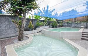 a swimming pool in a backyard with a swimming pool at Dedaunan Guesthouse in Tlekung