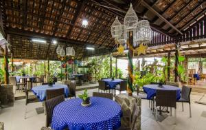 a restaurant with blue tables and chairs and plants at Dedaunan Guesthouse in Tlekung