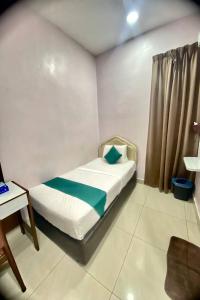 a small bedroom with a bed and a desk at Sun Tree Hotel at Triang in Kampong Kerayong