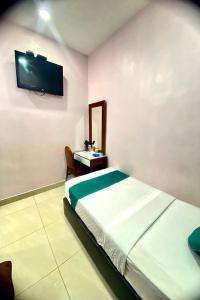 a bedroom with a bed and a tv on the wall at Sun Tree Hotel at Triang in Kampong Kerayong +46 photos