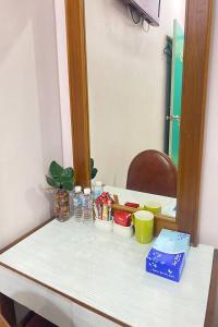 a table with a mirror and some dishes on it at Sun Tree Hotel at Triang in Kampong Kerayong