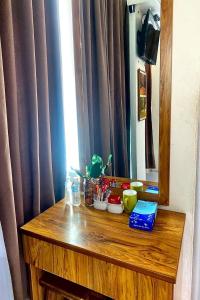 a wooden table with items on it in front of a mirror at Sun Tree Hotel at Triang in Kampong Kerayong