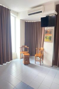 a room with two chairs and a flat screen tv at Sun Tree Hotel at Triang in Kampong Kerayong
